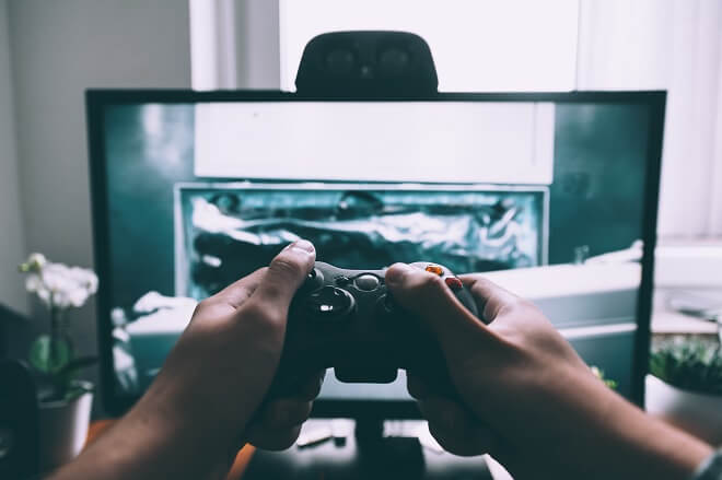 Man playing a video game to create a gameplay video